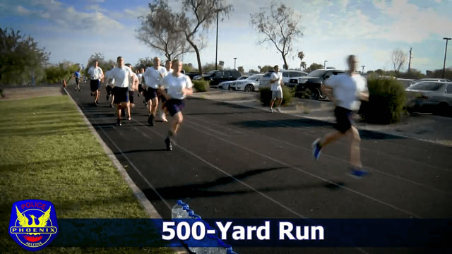 A group of people participating in a POPAT, running on a track for the 500-Yard Run.